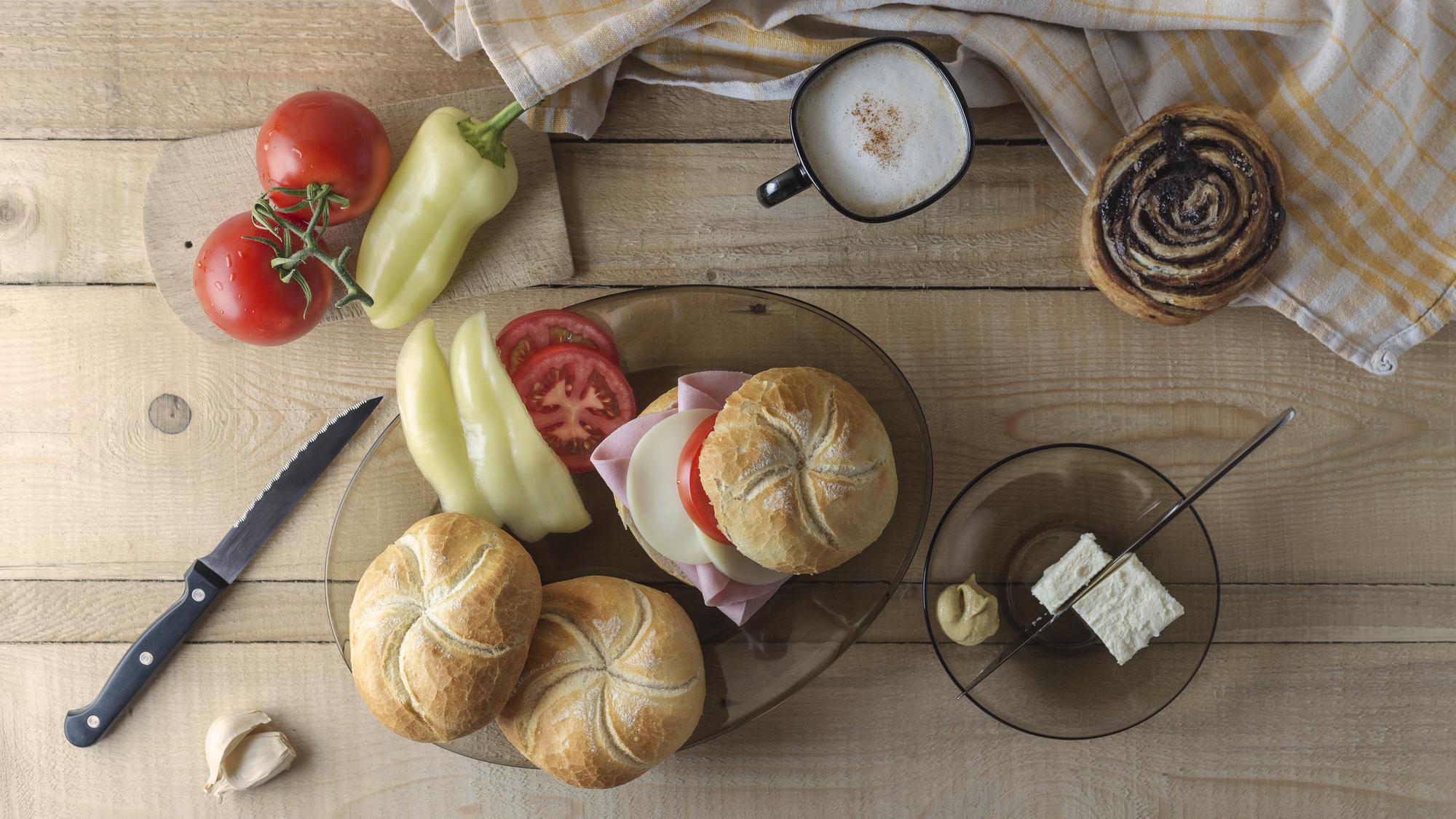 Close-up of artisan bread and seasonal vegetables on a wooden table