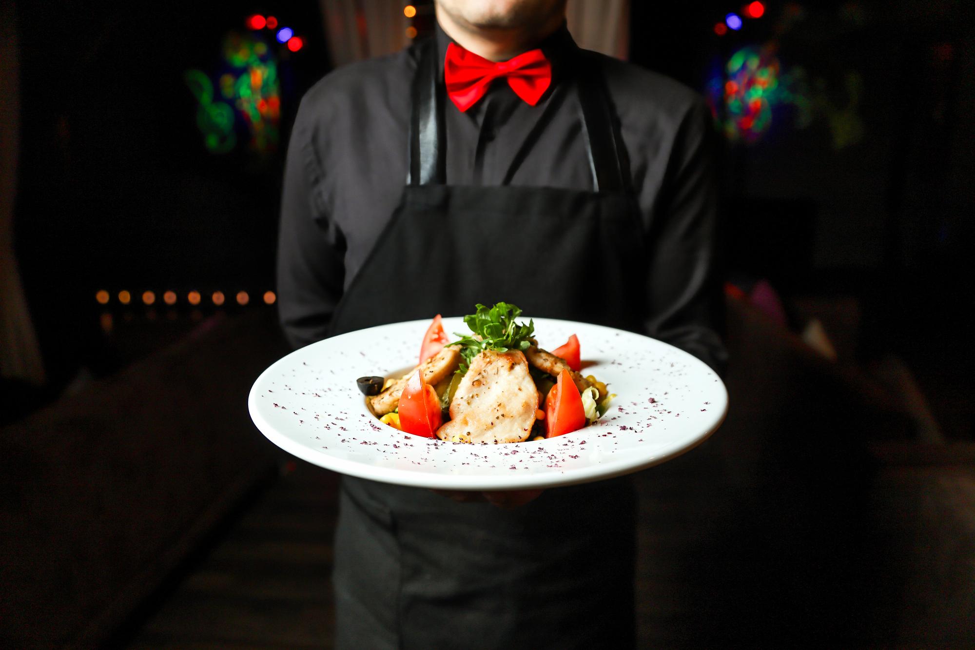 Chef serving plated food at event
